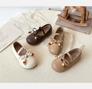 Detail view of Mary Jane baby shoes with bows and amber beads in four classic colors