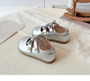 Détail de Mary Janes en cuir verni argenté avec doubles nœuds et perles