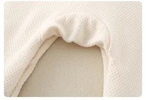 Detail shot of soft cream waffle knit cotton fabric texture for baby romper pajamas