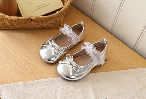 Detail of silver Mary Jane shoes with bow decoration and white lace elastic strap