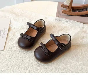 Detail of dark brown leather Mary Jane shoes with double bows for toddler girls