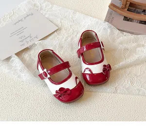 Detail von rot-weißen Mary-Jane-Schuhen mit Schleife und Katzenohren-Akzenten