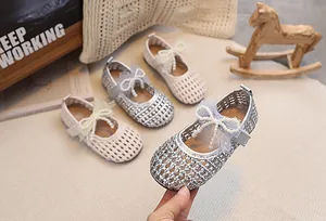 Dettaglio della trama traforata e del fiocco di perle sulle scarpe mary jane da bambina