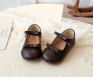 Close-up of dark brown Mary Jane shoes with double bow straps on a retro table