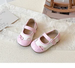 Details von rosa Mary Jane Schuhen mit Bären-Schnalle und Schleife auf weißer Spitze