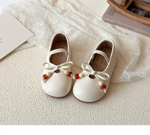 Detailed macro of cream Mary Jane shoe with bow and bead accents on lace background