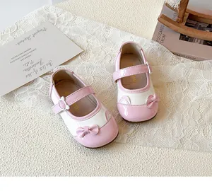 Detailansicht der pink-weißen Mary Jane Schuhe aus Lackleder mit Schleife auf Spitze