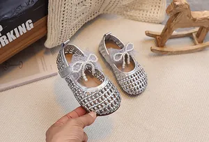 Dettaglio delle ballerine Mary Jane intrecciate argento con fiocco in pizzo e perle e velcro