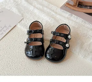 Détail de chaussures Mary Jane en cuir verni noir brillant avec perles pour bébé