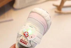 Detail of baby sneakers featuring breathable mesh and light-up elephant pendant