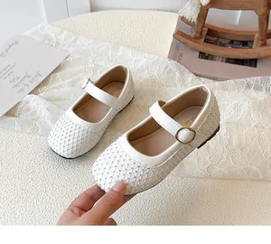 Details von weißen Mädchen Mary Jane Schuhen mit funkelndem Strassgitter und Goldschnalle