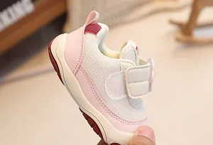 Detail of pink toddler sneakers showing breathable mesh upper and flower velcro closure