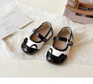 Detail von Mädchen Mary Janes mit schwarzer Schleife, Katzenohren und Blumenschnalle