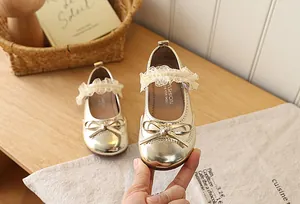 Detailed view of golden girls Mary Janes with bow detail and delicate lace trim