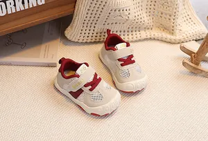 Close-up of toddler mesh sneakers with breathable cream fabric and red velcro straps