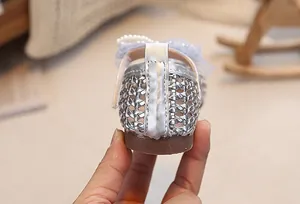 Vista posteriore di scarpe da principessa argento con dettagli in pizzo e perle