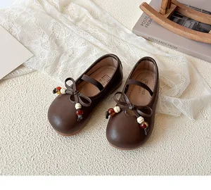 Detail of retro dark brown leather Mary Jane shoes with beaded bow and soft rubber sole