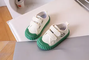 Detail of kids canvas shoes featuring dual velcro straps and green rubber toe protection