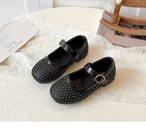 Detailaufnahme der schwarzen Mädchen Mary Jane Schuhe mit Netzstruktur und Gold-Schnalle