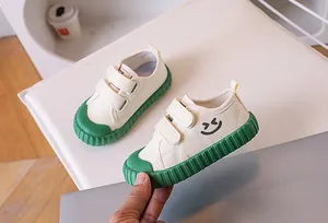 Detail of kids canvas shoes with green rubber soles and hook-and-loop straps