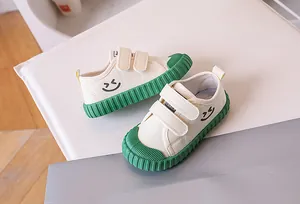Close-up of children's canvas shoes with green rubber toe cap and smiley face print