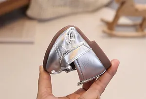 Detailansicht der flexiblen Gummisohle bei silbernen Babyschuhen mit Spitze