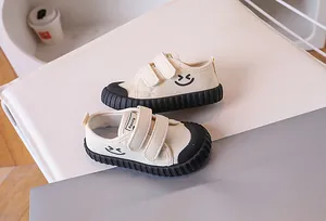 Detail of kids canvas shoe featuring double velcro straps and a black rubber toe cap