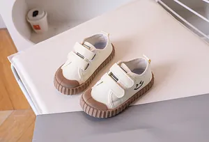 Detail of kids canvas shoes featuring dual velcro straps and protective rubber toe cap