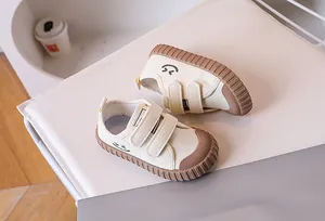 Close-up of kids canvas shoes with velcro straps and a smile print on a soft cushion