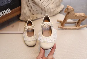 Nahaufnahme der Baby Mädchen Prinzessin Schuhe mit Spitze und süßem Schleifen-Detail