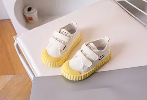 Detail of kids canvas shoes with double velcro straps and yellow rubber sole