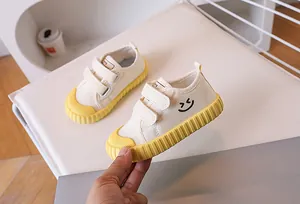Close-up of kids canvas shoes with yellow rubber sole and protective toe cap