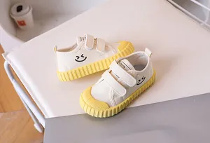 Detail of kids canvas shoe showing the smiley face icon and anti-slip yellow rubber sole
