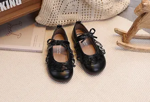 Nahaufnahme schwarzer Lauflernschuhe für Mädchen mit Spitze und dekorativer Schleife