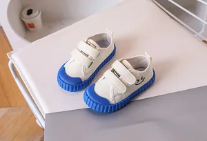 Close-up of children canvas shoes with blue rubber toe caps and double velcro straps