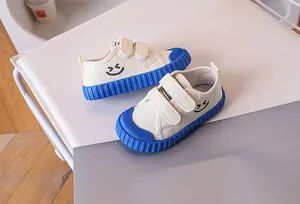 Close-up of kids canvas shoe with blue rubber sole and double hook-and-loop straps