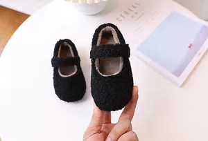 Detalle de zapatos Mary Jane de felpa negra para niñas con piel sintética suave y velcro