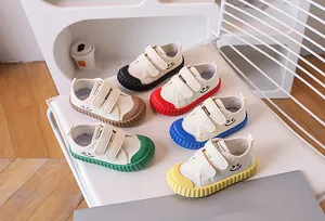 Close-up of six colorful canvas shoes for kids with smile embroidery and velcro straps
