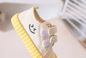Detail of toddler canvas shoes with non-slip yellow rubber sole and velcro straps