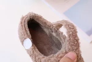 Detalle macro de zapatos de invierno para bebés en felpa marrón con suave forro interior