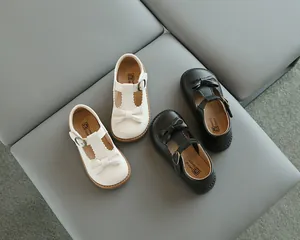 Vue de dessus de chaussures Mary Jane blanches et noires pour filles avec nœuds et boucles