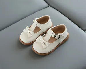 Détails de mocassins crème pour filles avec bords festonnés et nœud élégant