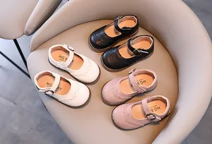 Top view of girls' Mary Jane shoes in black, white and pink with brogue cut-out details