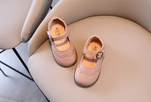Detail view of pink girls Mary Jane shoes featuring brogue carvings on soft leather