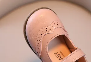 Close-up of pink girls' leather shoe with detailed Brogue perforations and fine stitching