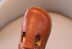Détail de chaussures Mary Jane marron pour filles avec motifs perforés de style brogue