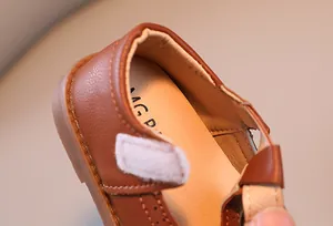 Gros plan détaillé de chaussures en cuir marron pour filles avec coutures et velcro