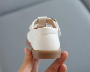Détail des chaussures Mary Jane blanches pour filles avec coutures au talon et semelle gomme