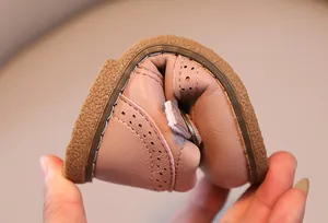 Detail showing the ultra-flexible rubber sole and breathable brogue carvings on pink leather