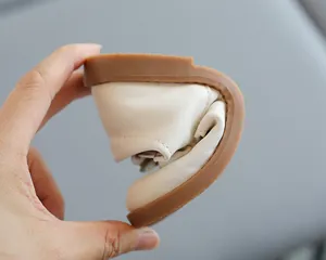 Gros plan d'une chaussure souple en cuir crème pour bébé montrant la semelle flexible
